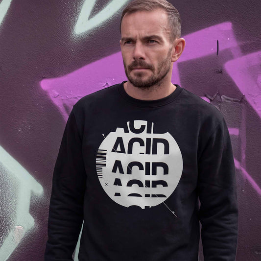 Man wearing a black acid house sweatshirt with white ACID DROP screen print, standing outdoors.