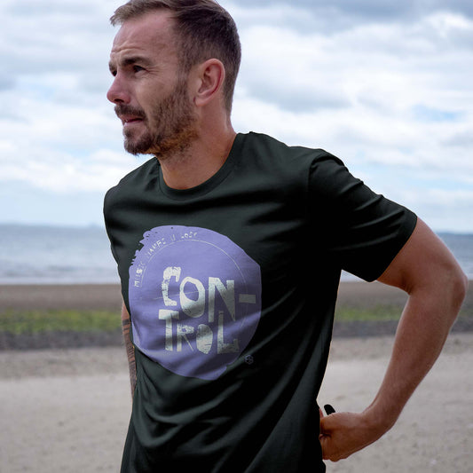 Man wearing a black t-shirt with a purple music makes you lose control graphic and text outdoors