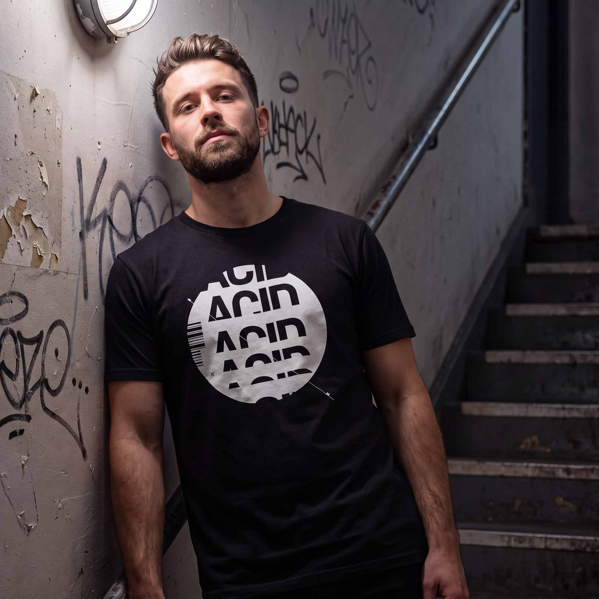 Man wearing a black acid house t-shirt with white ACID DROP screen print