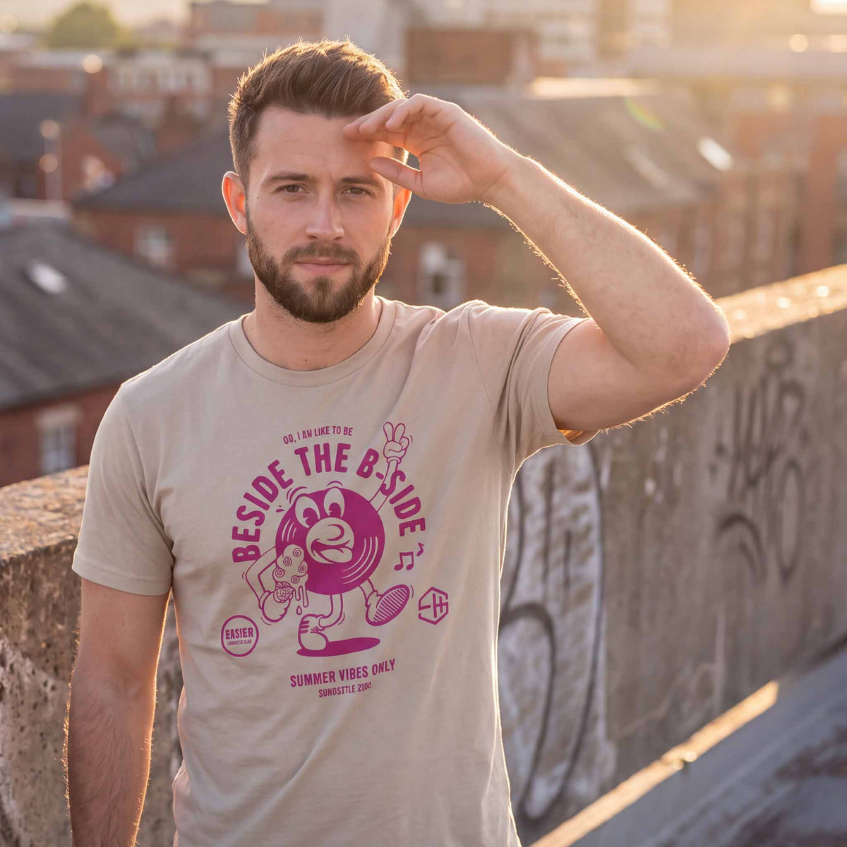 Man wearing a dust summer vibes t-shirt with a graphic design outside