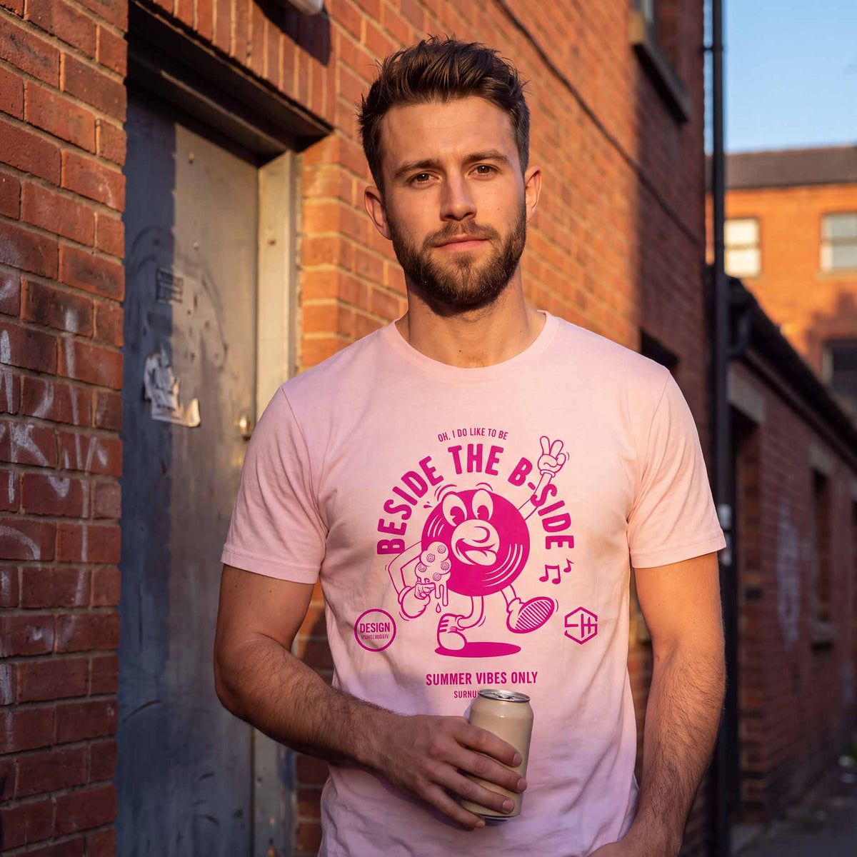 Man wearing a pink summer vibes t-shirt with a graphic design outside