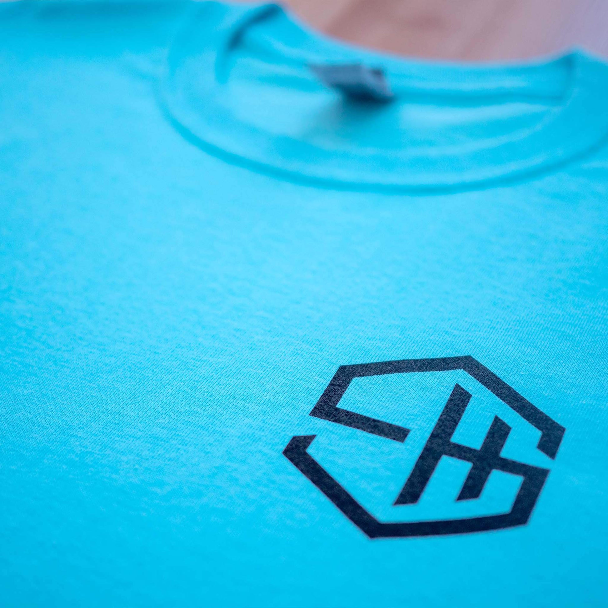 Subhustle logo chest print detail on sky blue acid house music tee design